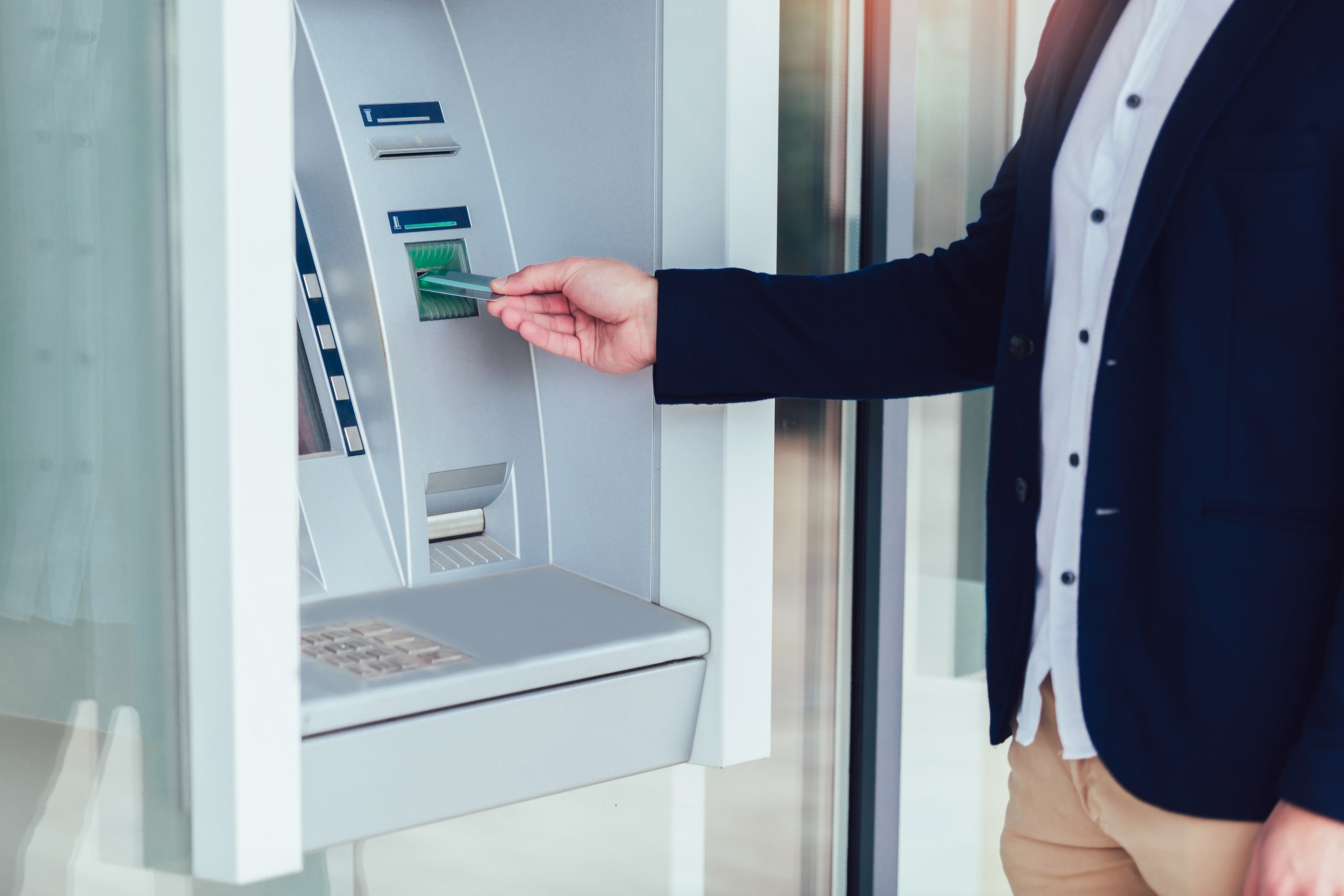 A man inserting his GLCU debit card into a CO-OP atm