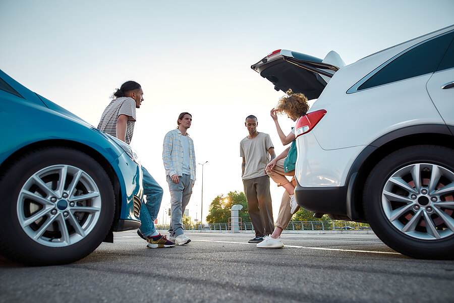 A group of friends talking about their new cars.